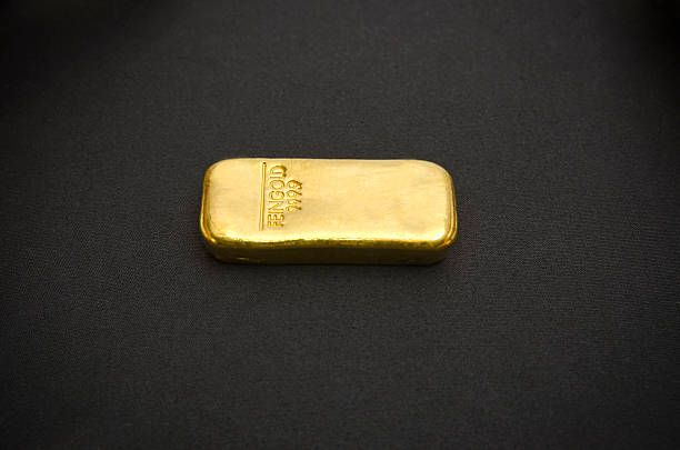 Barra de ouro em um fundo preto - foto de acervo
