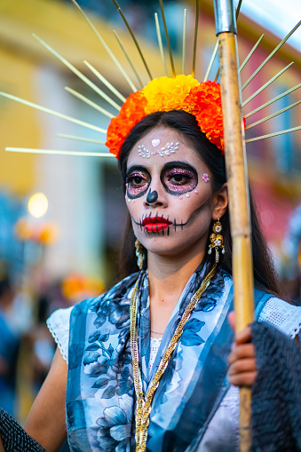 Oaxaca, Mexico - November 02, 2022: Dancer with Mexico Catrina makeup in the parade is an annual indigenous cultural event with traditional dancing.