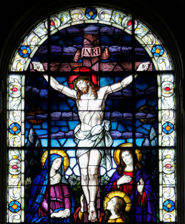 Detail of a magnificent stained glass window from Saint Edward Catholic Church in Palm Beach, Florida. Completed on February 13, 1927, this window depicts Christ on the Cross with the verse from Luke, \