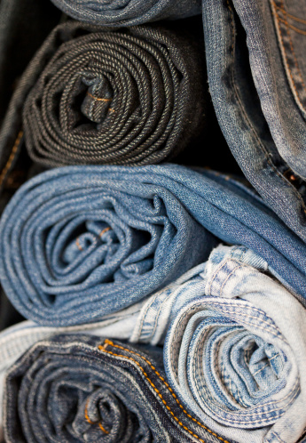 stacked and rolled denim blue jeans of varying shades
