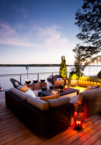 Patio over looking the lake at twilight with lanterns and candles. Vertical, space for copy.