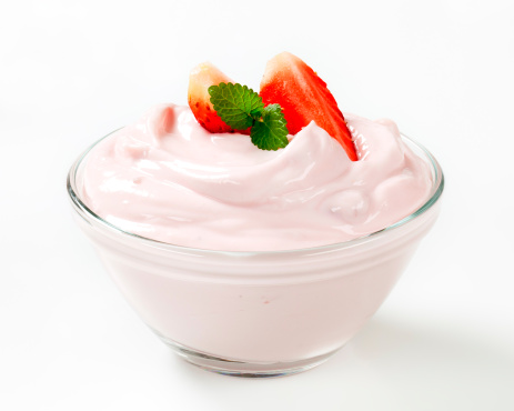 white cream with strawberries and mint in a small glass bowl