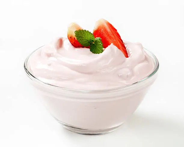 white cream with strawberries and mint in a small glass bowl