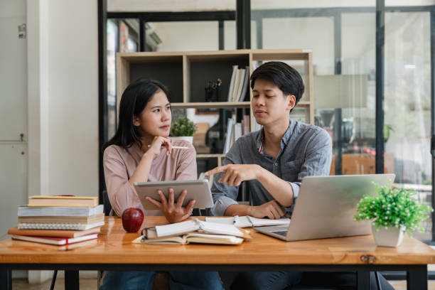 istock Male and female students reading a book. library research, reading and students with a book, learning knowledge at college. Scholarship, smile at university for education 1597627566