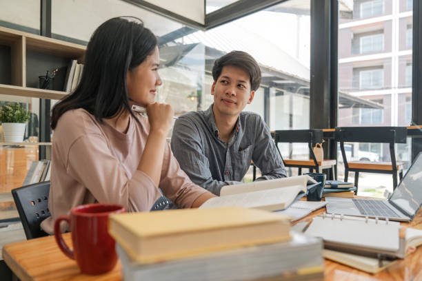 istock Male and female students reading a book. library research, reading and students with a book, learning knowledge at college. Scholarship, smile at university for education 1597659364