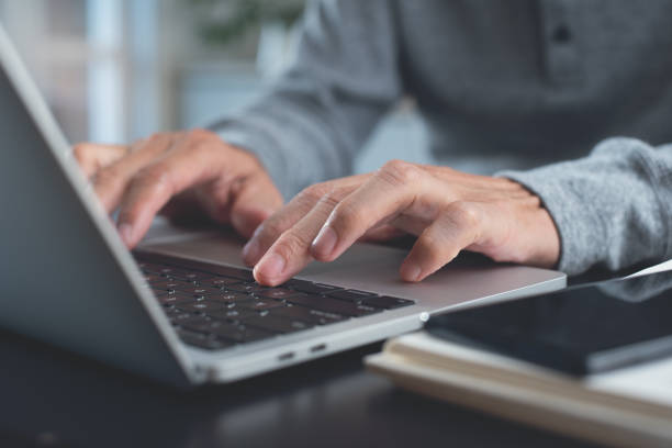 istock Man hands typing on laptop computer keyboard, surfing the internet online working from home office 1597664094