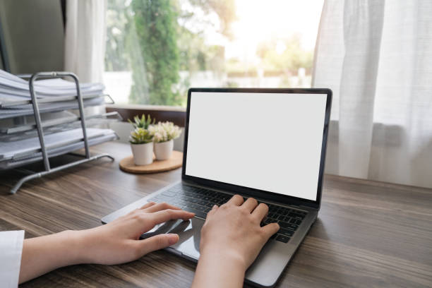 istock Woman hands typing on the laptop with empty blank white screen mockup. Computer is laying on the table. Person working from home concept. Copy space area for text 1597665626