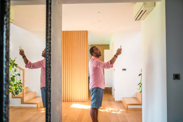 istock Mature Hispanic Male Using A Remote Control To Setup The Air Conditioning At Home 1597671422