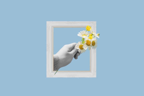 istock Digital collage modern art. Hand holding flowers, in picture frame 1597683001