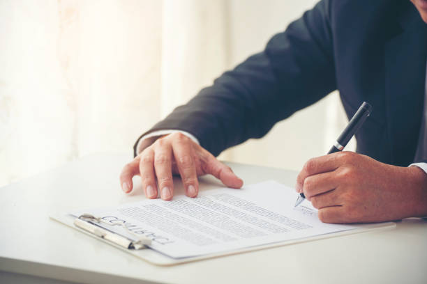 istock Businessman hand using pen signing on new contract to starting projects in conference room. Close up business manager man hands sign contract legal document in meeting room. Business agreement concept 1597701308