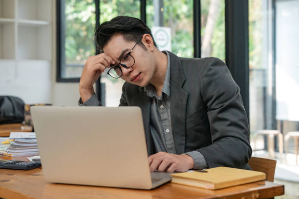 istock Business man from work stress concept. asian man feeling tired suffering using computer working work place 1597707471