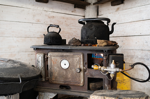 Kettles and old cast iron gas cooker in a rustic house in El Calafate Argentina.