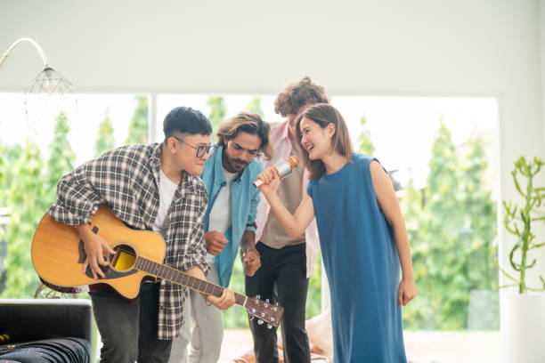 Group of friends playing karaoke at home