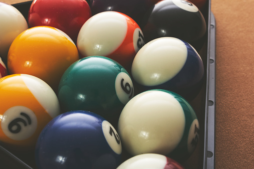 A view of a set of pool balls organized inside a triangle rack on a pool table.