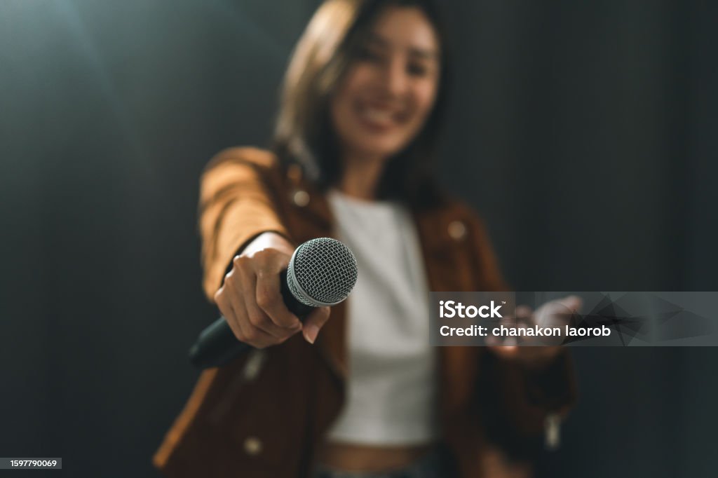 Close up woman hand holding High quality dynamic microphone and singing song or speaking talking with people on isolated white background. Woman testing microphone voice for interview Microphone Stock Photo