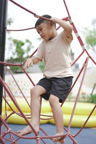 istock Boy climbing rope equipment 1597790131