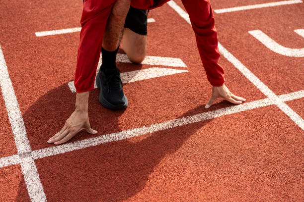 istock Young handsome indian man doing start pose before running exercise on track in sport stadium. Challenge race of athletes running in the starting point. Young asian man in sport athlete uniform 1597790213