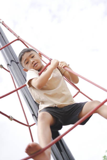 istock Boy climbing rope equipment 1597790216