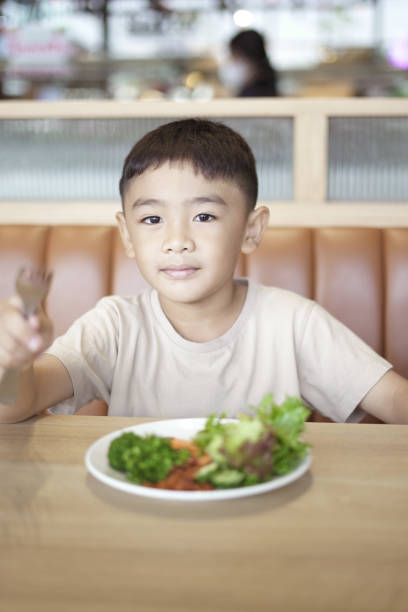 istock Child Boy eating vegetable salad 1597790969