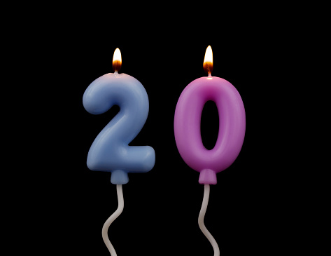 Burning air balloon shaped birthday candles isolated on black background, number 20