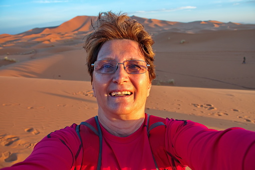 Senior woman taking selfie in Sahara desert