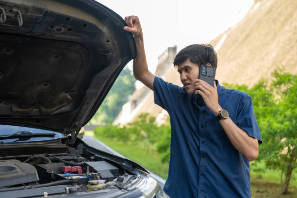 istock Young asian man has broken down car on the road she feeling serious and stressed. Look for someone help. Using smartphone Call Emergency assistance or insurance service. 1597809460