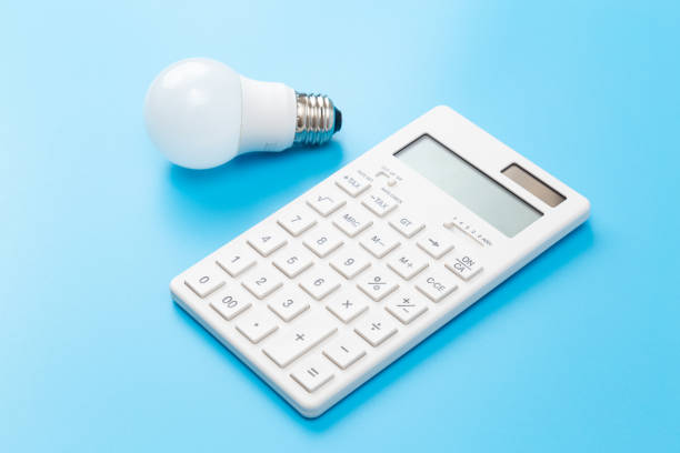 istock LED bulb and calculator on blue background. 1597811091