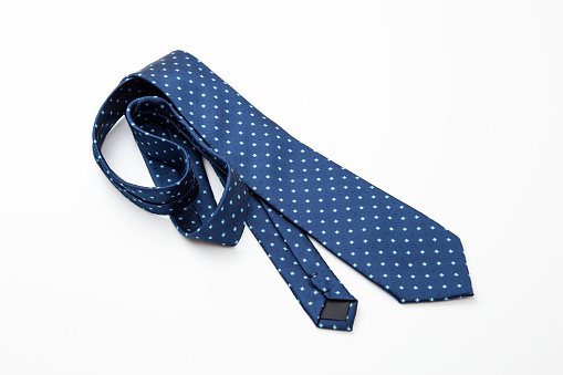 A tie with a polka dot pattern on a white background.