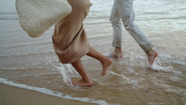 Sweethearts feet running sand beach at sea vacation. Couple walking on shore