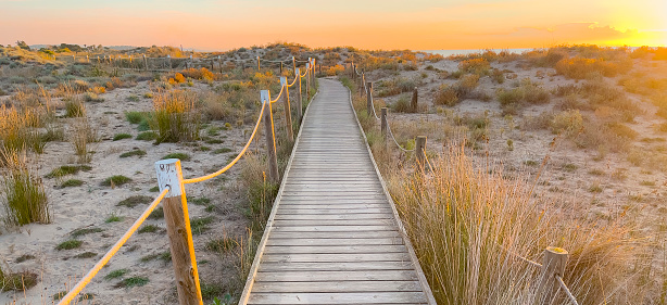 Wooden walkway to the beach at sunset