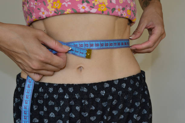 istock a girl measures her waist 1597958051