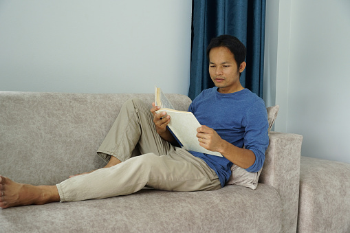 asian men reading a book in well-being at home.