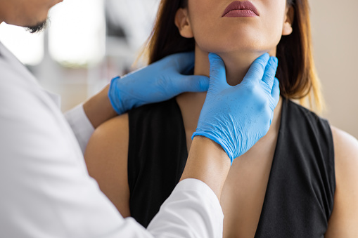 Doctor checking thyroid of a patient