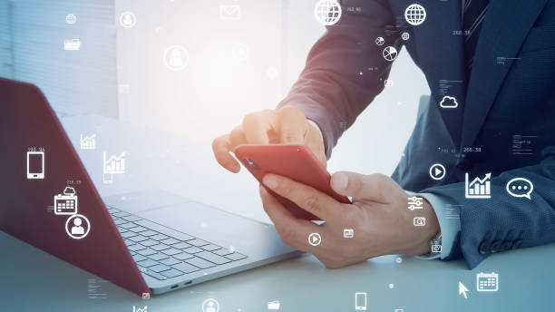 istock businessperson using a laptop PC and a smart phone. Communication network. 1598015882
