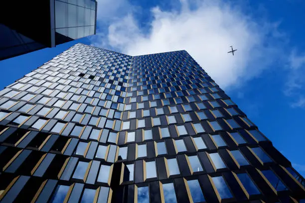 a tall skyscraper from the front with airplanes flying close by