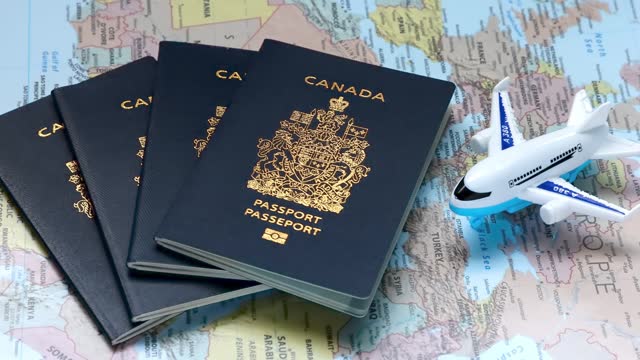 A person dropping Canadian passports on a world map with an airplane. Concept: Canadian citizens traveling abroad.