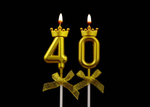 Golden birthday candles burning on black, number 40. stock photo