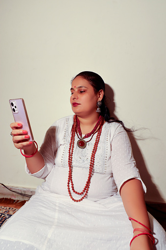 Female monk using mobile phone sitting portrait close up