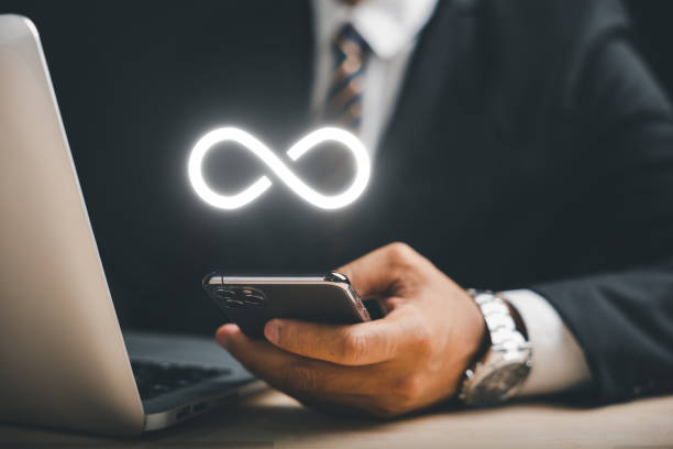 istock Businessman presents smartphone with infinity symbol 1598042299