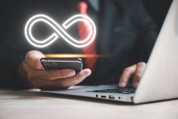 istock Businessman presents smartphone with infinity symbol 1598042850