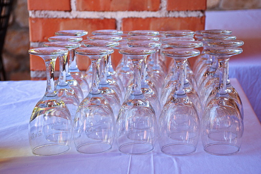 Group of glasses on the white table against the brick wall