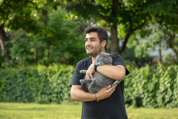 istock Young man is hanging around public park with his cat. 1598056516