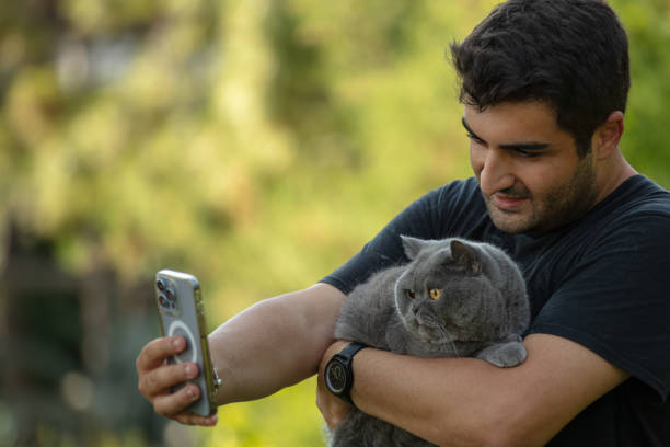 istock Young handsome man is taking a selfie with his cat. 1598056537