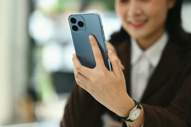 istock Closeup image of woman holding smartphone using mobile app, checking social media, texting message 1598056540