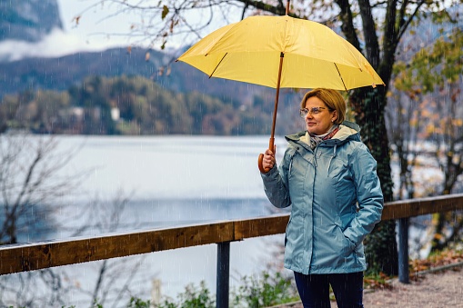 Mature woman enjoying a rainy day on Lake Bled in SLovenia