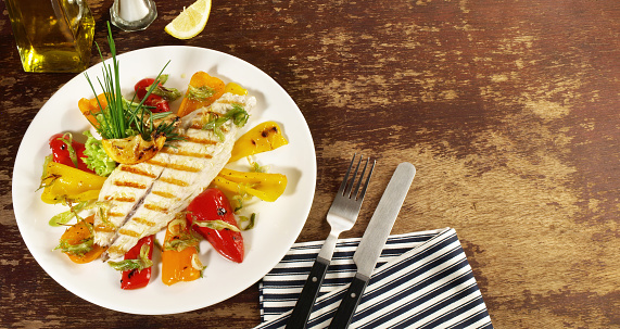Fish and Seafood - Grilled Fish Fillet with roasted Peppers and Vegetables - Low Carb Sea Food Plate on wooden Background - Panorama