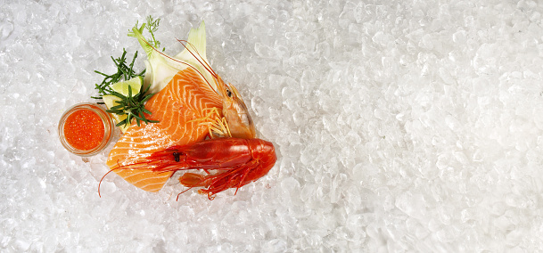 Fish and Seafood - Raw Salmon Fillet Steak with Tiger Prawns, Gamba Carabinero and Shrimp on Ice with white Background