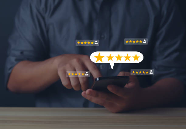 istock Closeup on customer hand pressing on smartphone screen with golden five stars feedback icon and great rating for best rating 1598119159