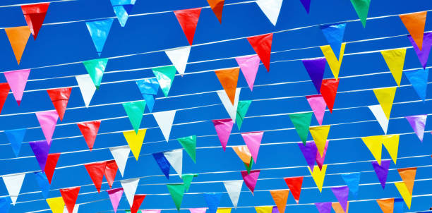 istock Multicolored triangular small flags to celebration party against blue sky.Street holiday concept for design. 1598121898