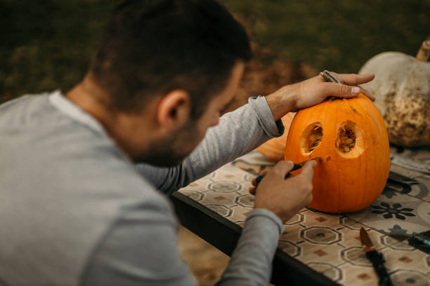 istock Father is decorating and cutting pumpkin for Halloween. 1598121910